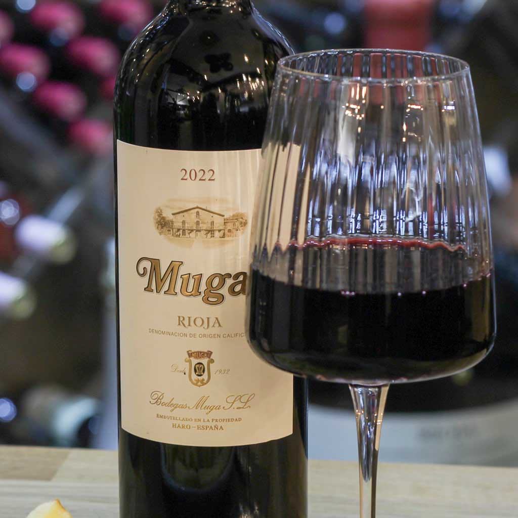 Botella Muga Rioja Crianza 2022 con copa de vino tinto — bodega The Beefeater Fuengirola