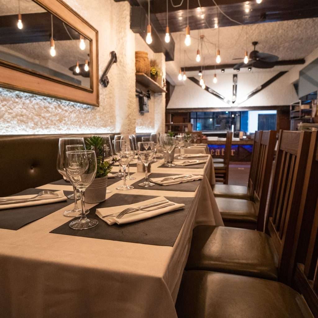 Sala interior con mesas preparadas y banquetas en el restaurante asador The Beefeater Fuengirola