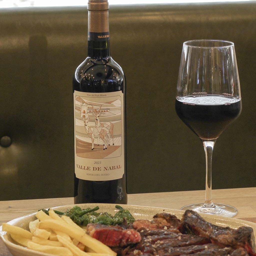 Botella Valle de Nabal Ribera del Duero con carne a la brasa y guarnición — The Beefeater Fuengirola